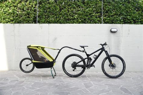 genitori in bici con carrello bambini