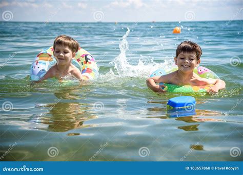 Bambino sorridente che galleggia con un salvagente colorato