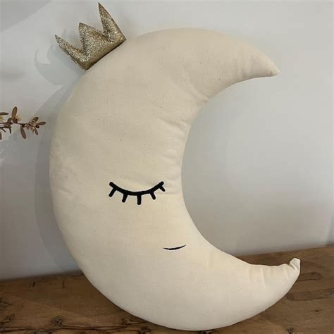 Dettaglio dei decori luminescenti a forma di luna e stella su mobile in legno