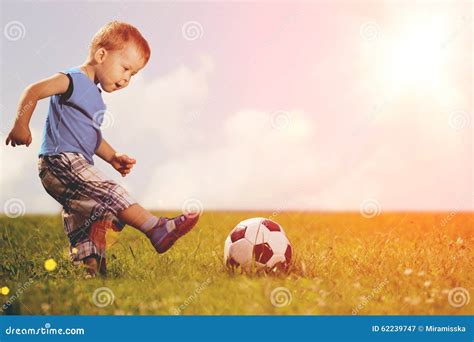 Bambino piccolo che calcia una palla colorata