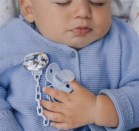 Bambino con ciuccio e una custodia per ciuccio appesa alla borsa