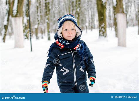 Bambino con sciarpa che gioca all'aperto in inverno