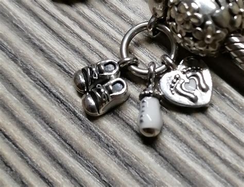 Design del charm bebè con biberon, scarpine e impronte