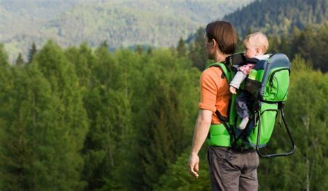 famiglia in escursione con zaino porta-bambino su sentiero di montagna