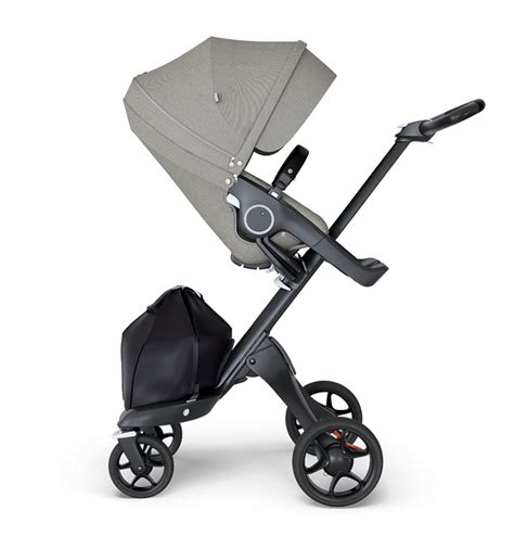 Bambino seduto su un passeggino Stokke che esplora il mondo