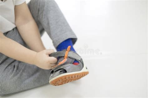 Bambino che prova le scarpe con la supervisione di un genitore