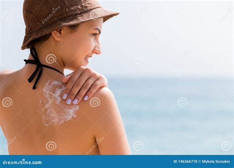 bambino protetto dal sole con cappello e crema solare
