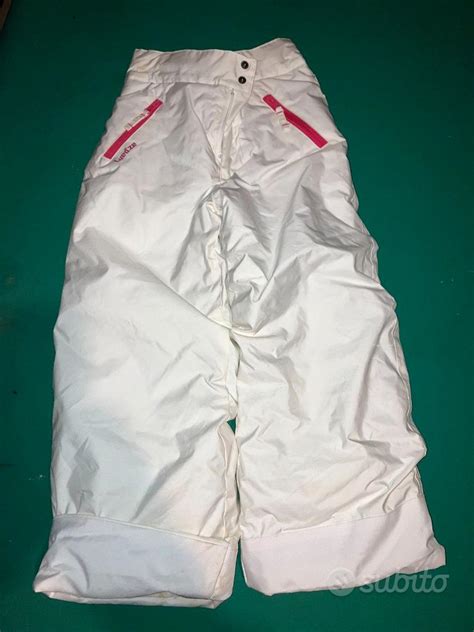 Bambina che gioca sulla neve indossando pantaloni da sci tecnici