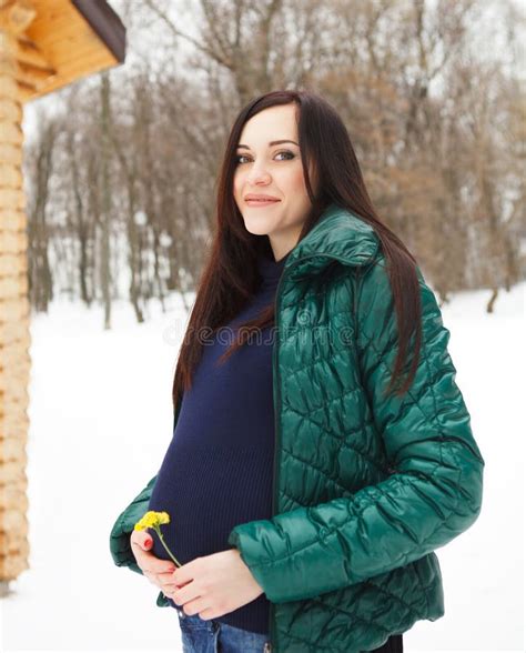 Donna incinta che indossa abiti invernali a strati