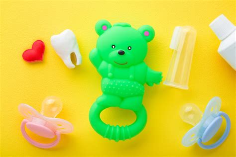 Dettaglio ravvicinato di un ciuccio in plastica trasparente inserito in un sacchetto di confetti bianco