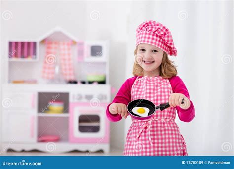 Bambina che gioca con una cucina giocattolo