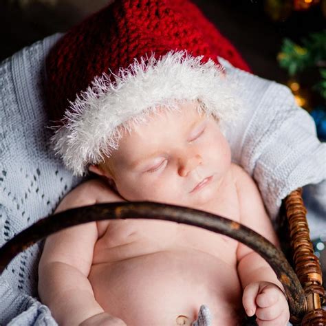 Neonato in abito natalizio con cappellino