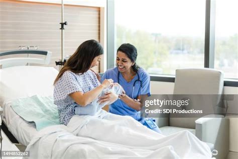 A midwife assisting a new mother and baby in a hospital setting