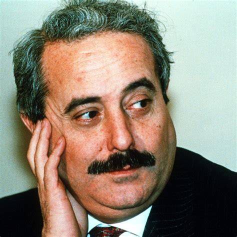 Ritratto stilizzato di Giovanni Falcone circondato da simboli di pace e giustizia