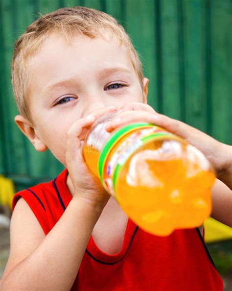 Bambino che beve una bevanda arancione