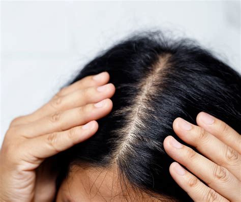 genitore che massaggia delicatamente il cuoio capelluto del neonato con olio