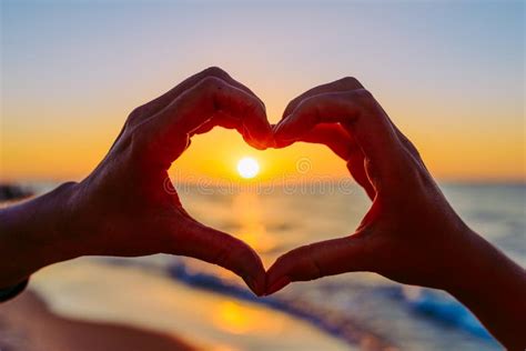 Coppia in attesa che forma un cuore con le mani sul pancione