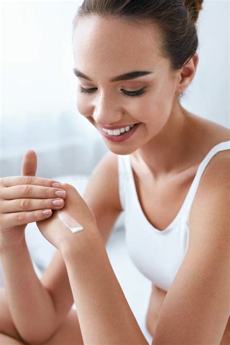 Immagine di un adolescente che applica una crema sulla pelle per prevenire le smagliature