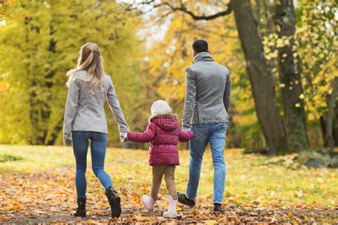 Una famiglia felice che passeggia al parco con un passeggino moderno