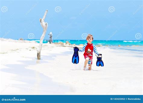 bambino che gioca in spiaggia protetto dal sole
