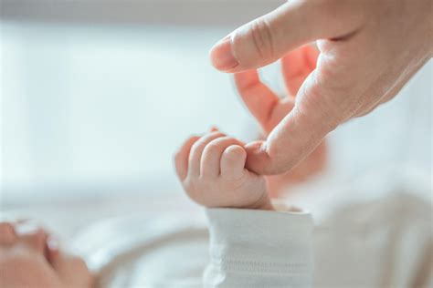 Madre e figlio neonato mano nella mano