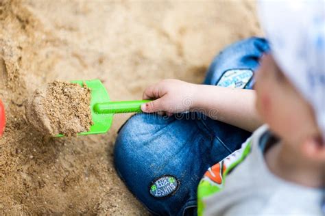 Bambini che scavano in una sabbiera con attrezzi archeologici
