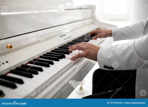 Mani di pianista su tastiera di un pianoforte antico