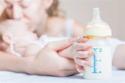 Bambino che tiene un biberon con maniglie