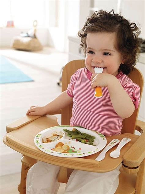 bambina che mangia serenamente utilizzando un set pappa colorato e stimolante