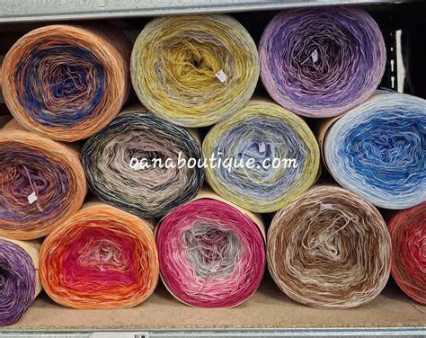 set di filati colorati in tonalità celesti e pastello disposti accanto a una tela aida pronta per il ricamo