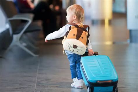 bambino che trascina un trolley colorato in aeroporto