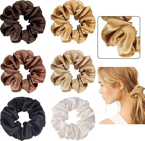 Una selezione colorata di elastici per capelli, scrunchies e fermagli disposti ordinatamente su un piano.