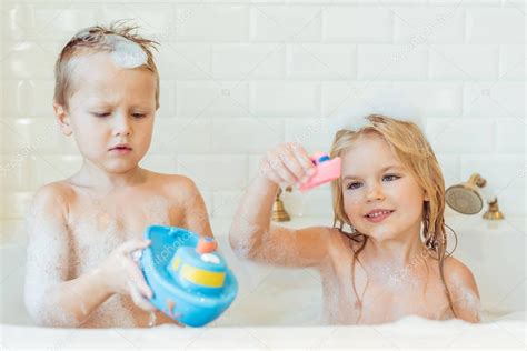 Bambino che fa il bagno in una vasca con schiuma delicata