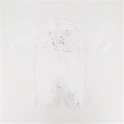 Dettaglio di una tutina neonato Pierre Cardin con fiocco e pizzo