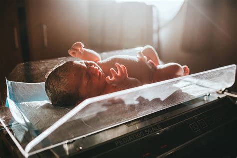 Neonato che viene pesato su una bilancia