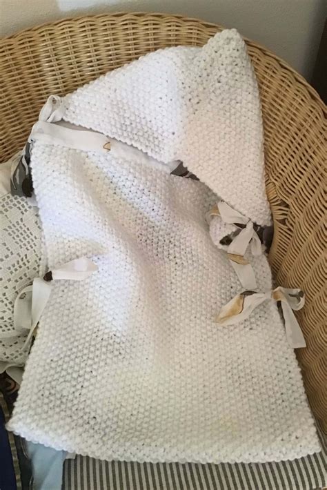 Bambino sorridente avvolto in un sacco nanna fatto a maglia
