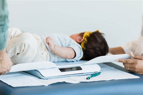 Bambino pesato su una bilancia pediatrica