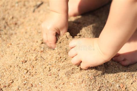 Mani di bambino che giocano con la sabbia cinetica