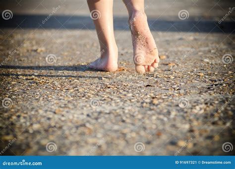 bambino che cammina a piedi nudi sulla sabbia