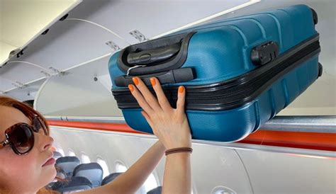 famiglia che ripone il passeggino compatto nella cappelliera di un aereo