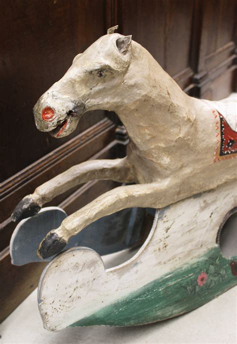 Un antico cavallo a dondolo in legno restaurato in un ambiente domestico
