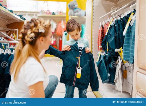 Children trying on clothes with parents